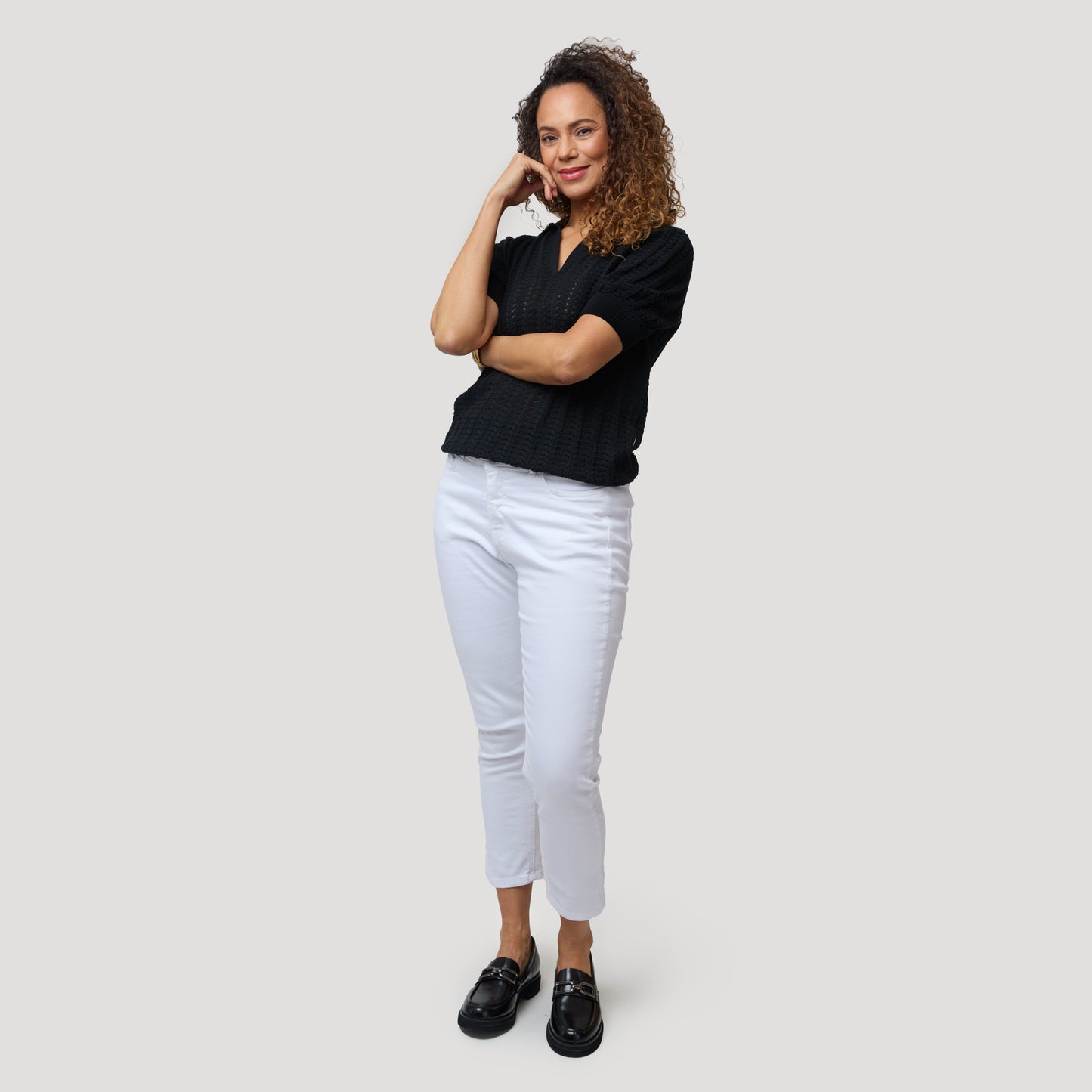 Musta toppi valkoisten lyhyiden farkkujen kanssa