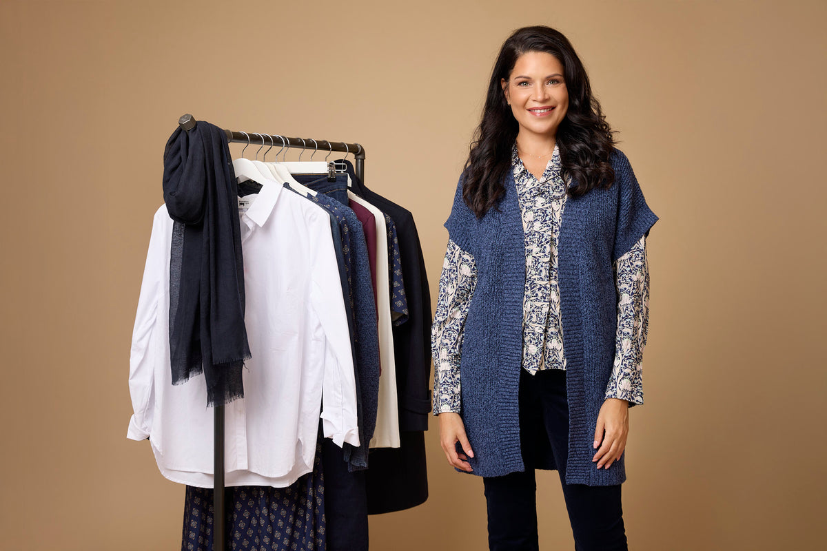 Kvinna med mönstrad blus och blå cardigan med en kapselgarderob för stilen classic