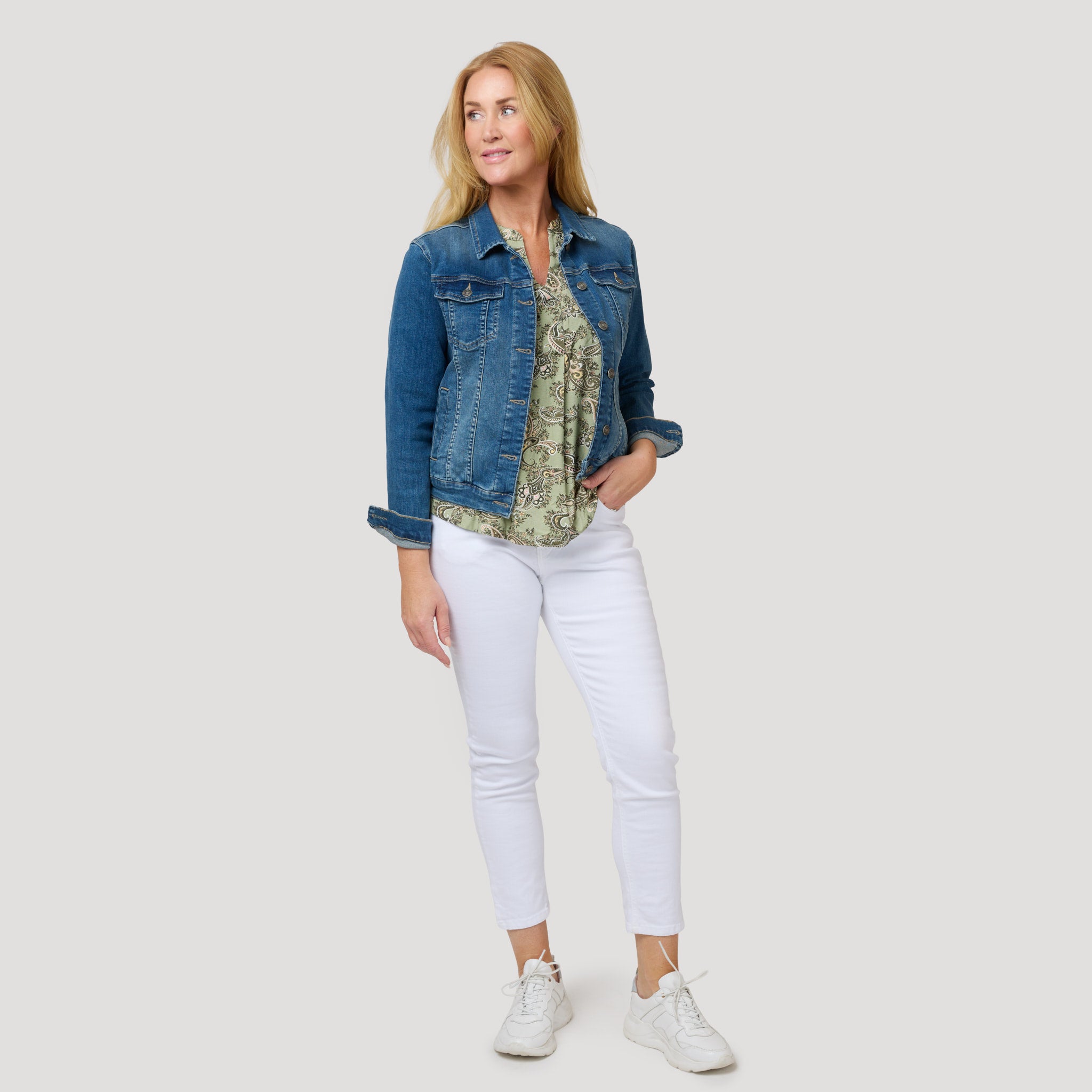 Somrigt med grön topp och vita jeans