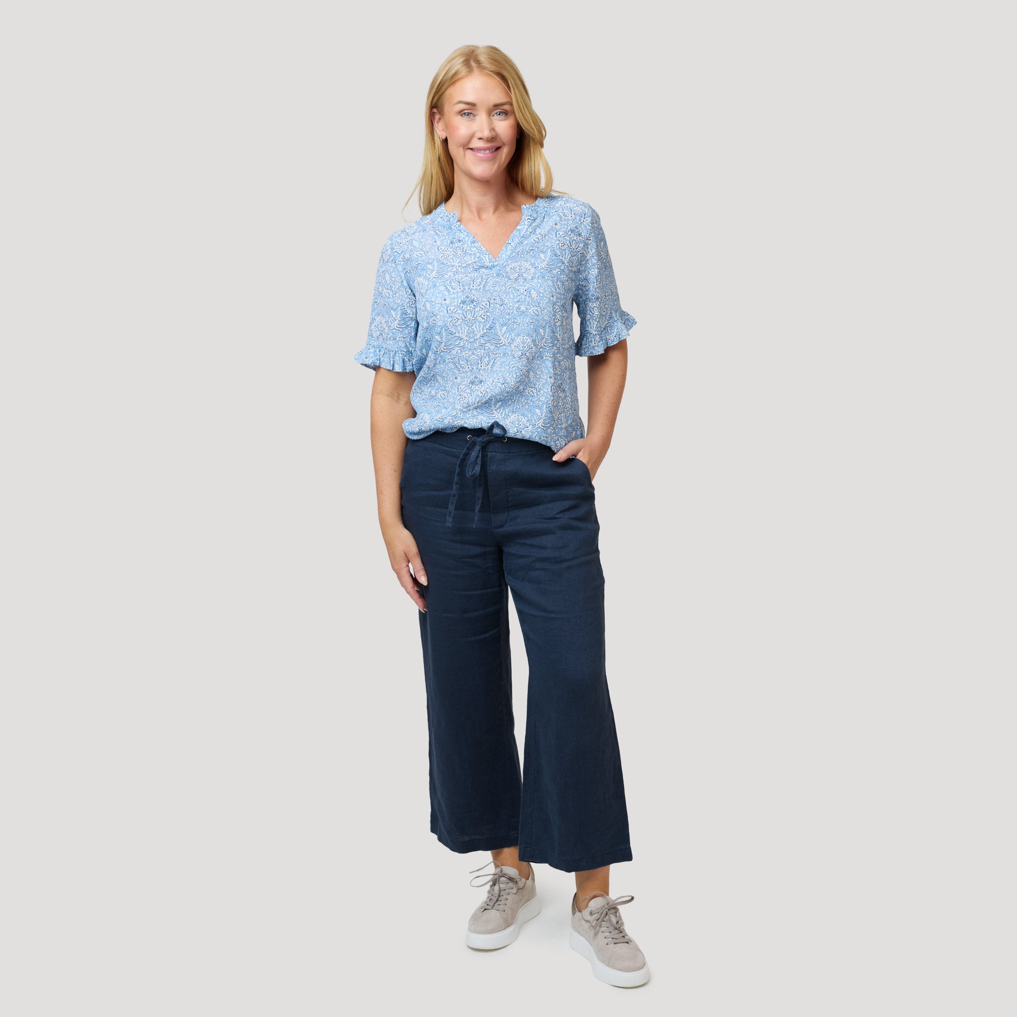 Vaaleansininen pusero tummansinisten pellavahousujen kanssa