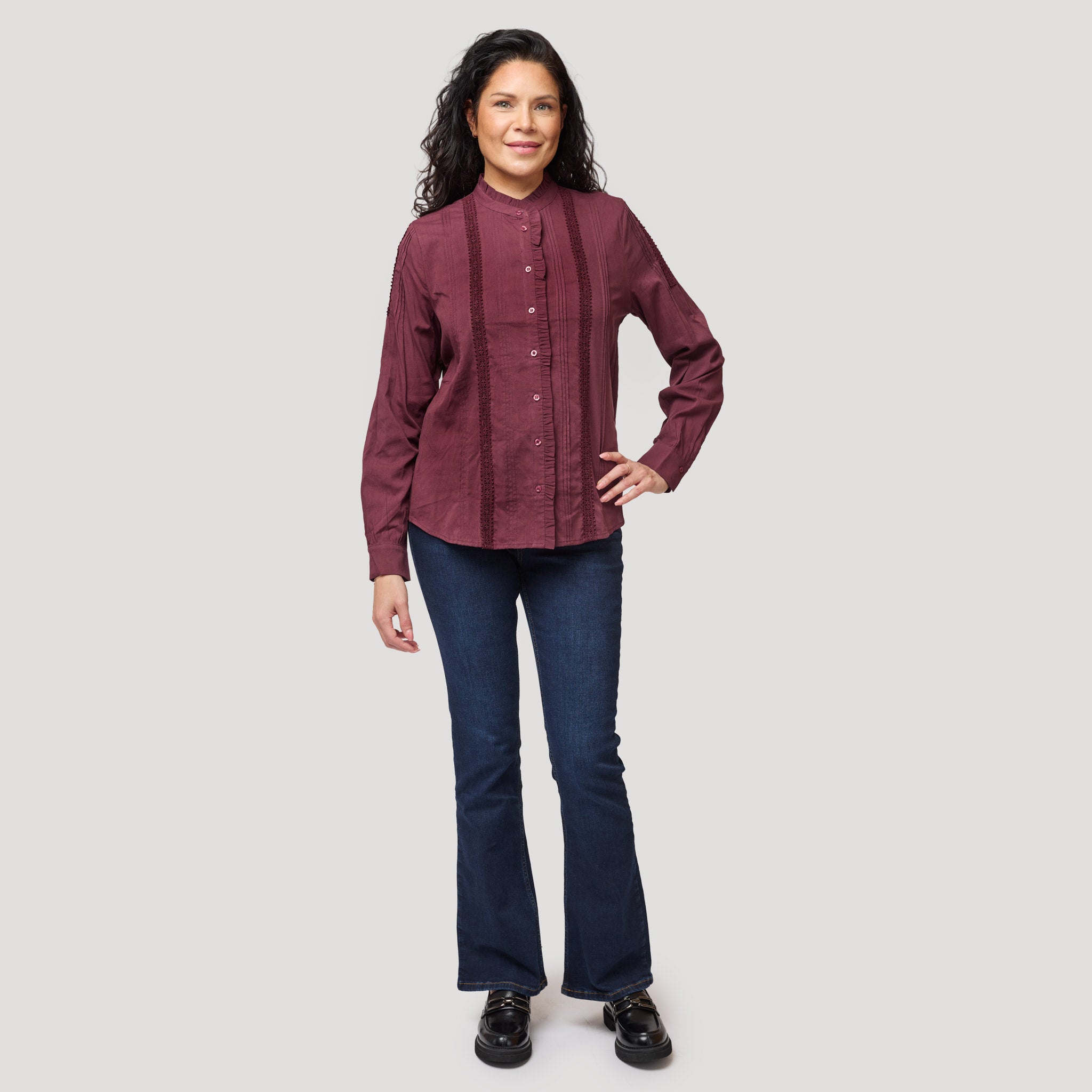 Viininpunainen pusero tummien bootcut-farkkujen kanssa