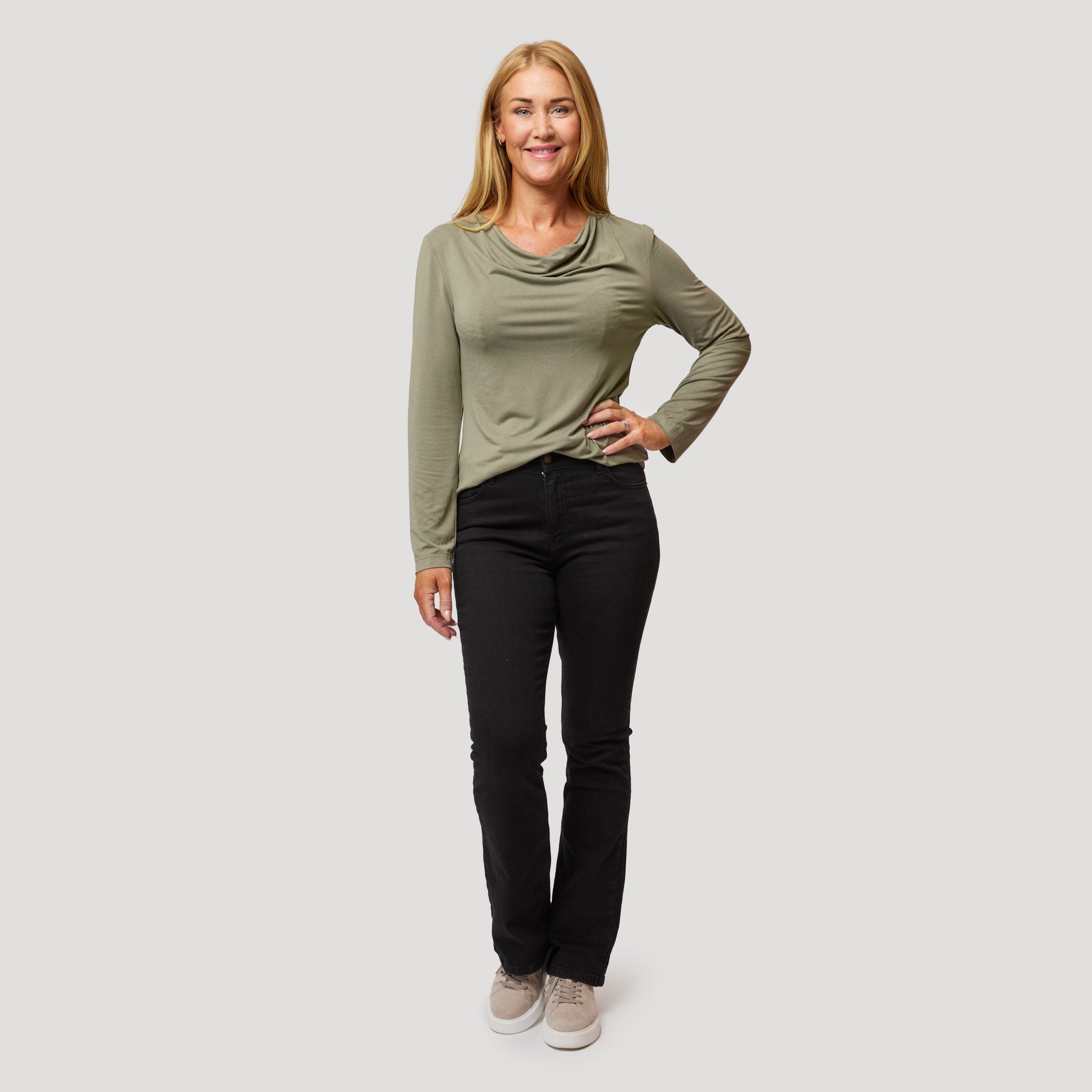 Vihreä toppi mustien bootcut-farkkujen kanssa