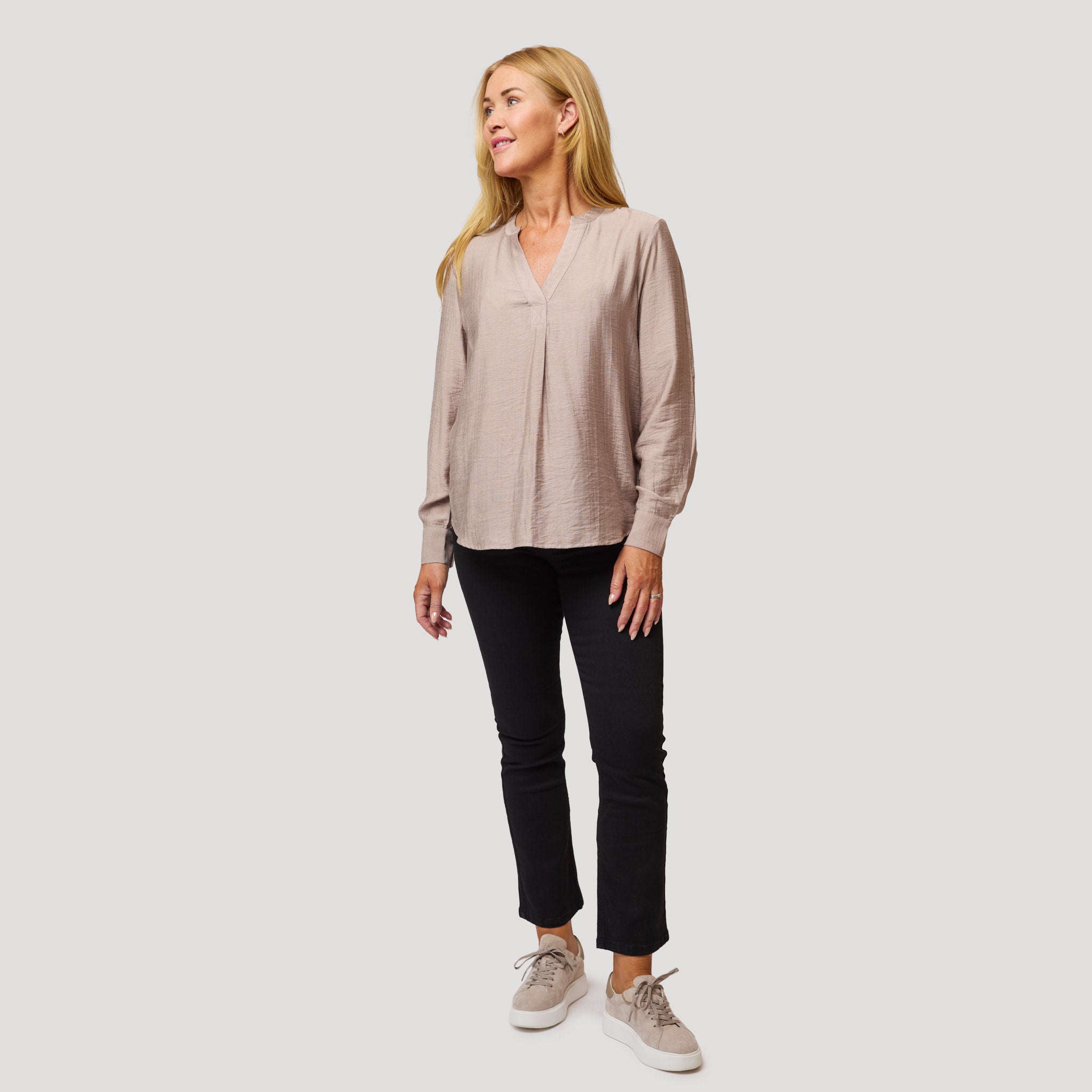 Beige pusero mustien kickflare-farkkujen kanssa