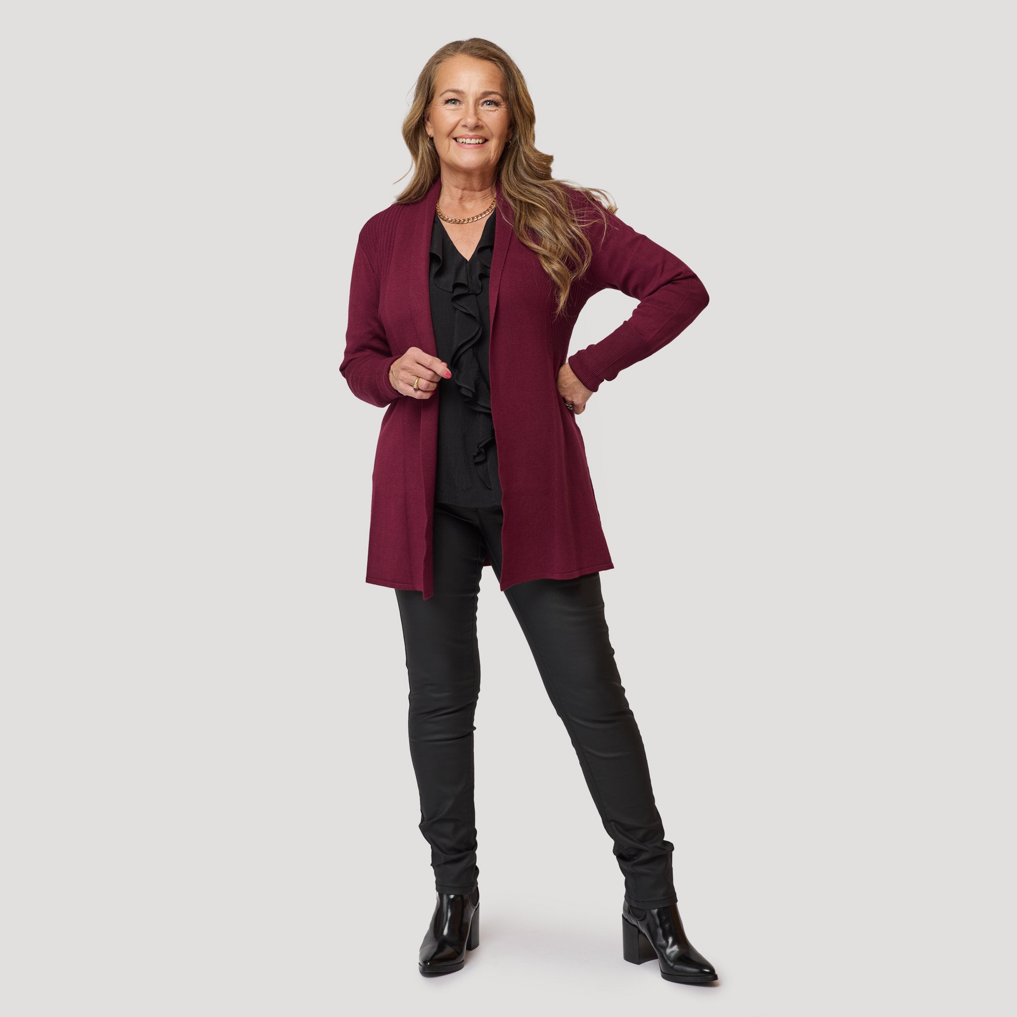 Svart volangblus under vinröd cardigan