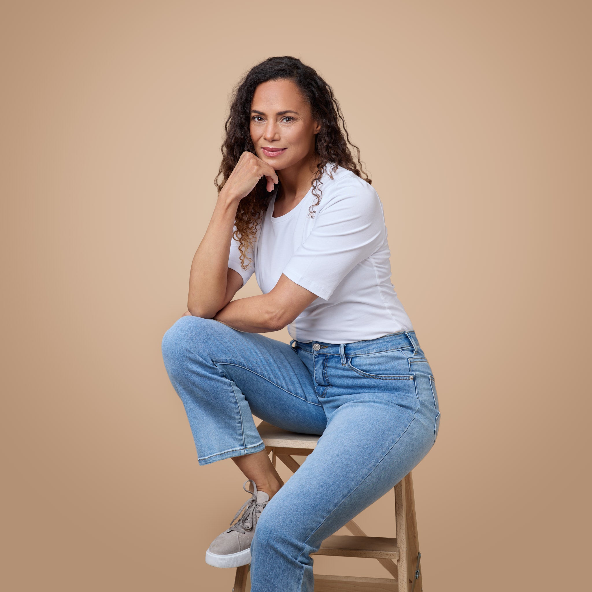 Valkoinen toppi vaaleansinisten farkkujen kanssa