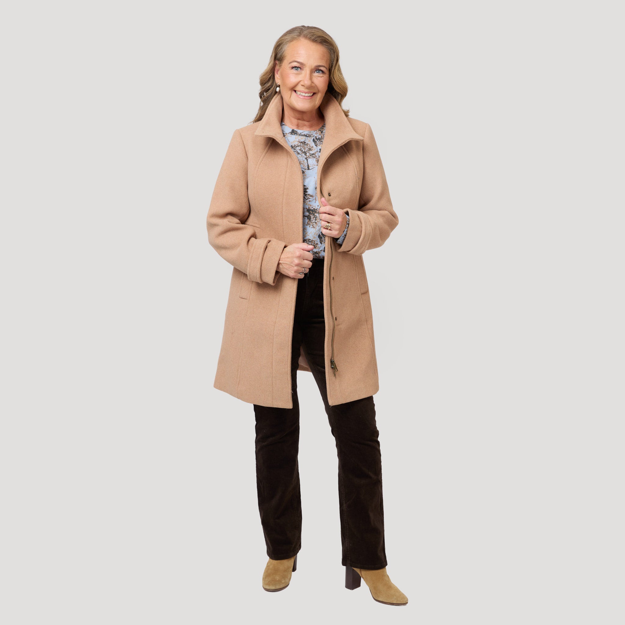 Vacker duvblå blus under beige kappa