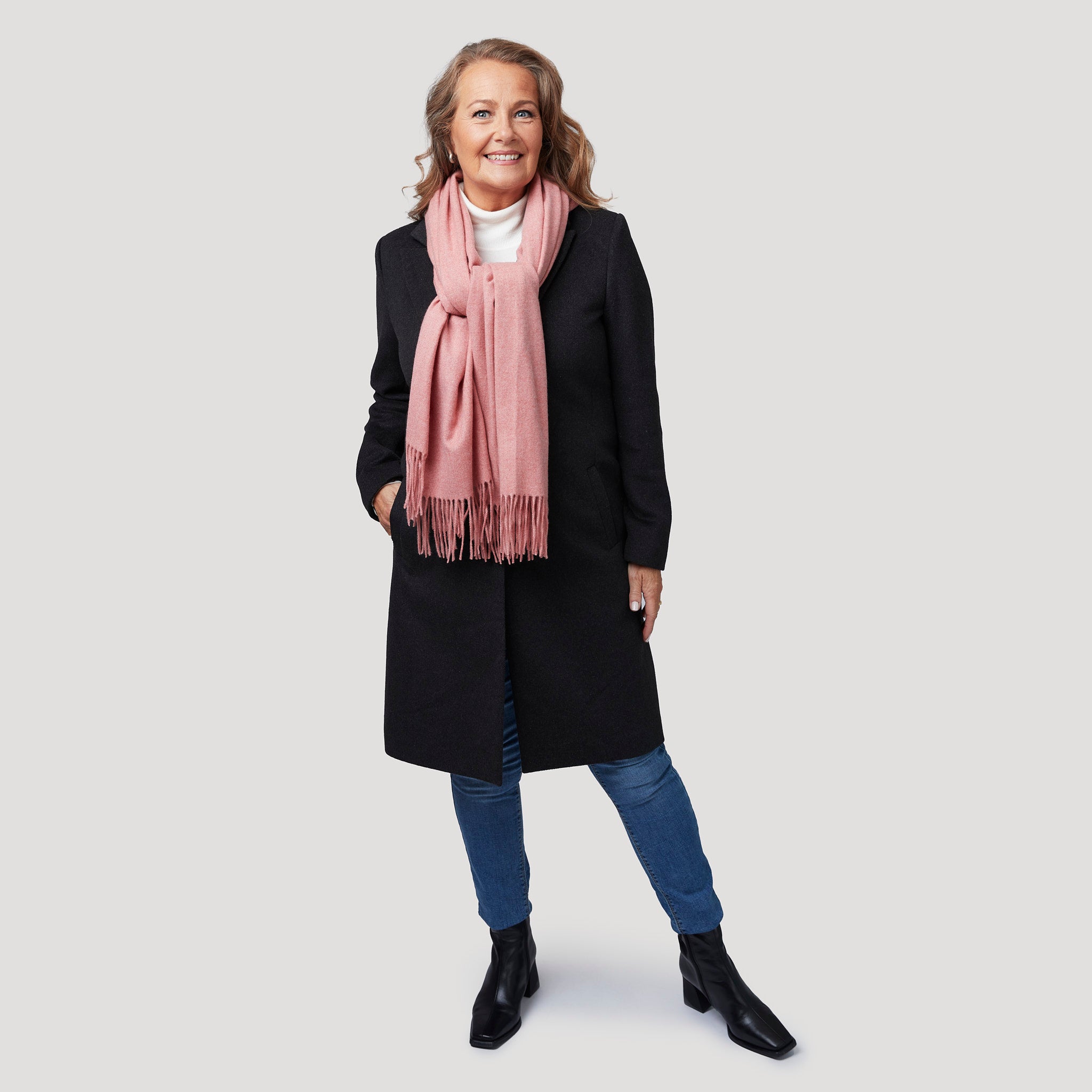 Mörkgrå kappa med polo och jeans samt rosa sjal
